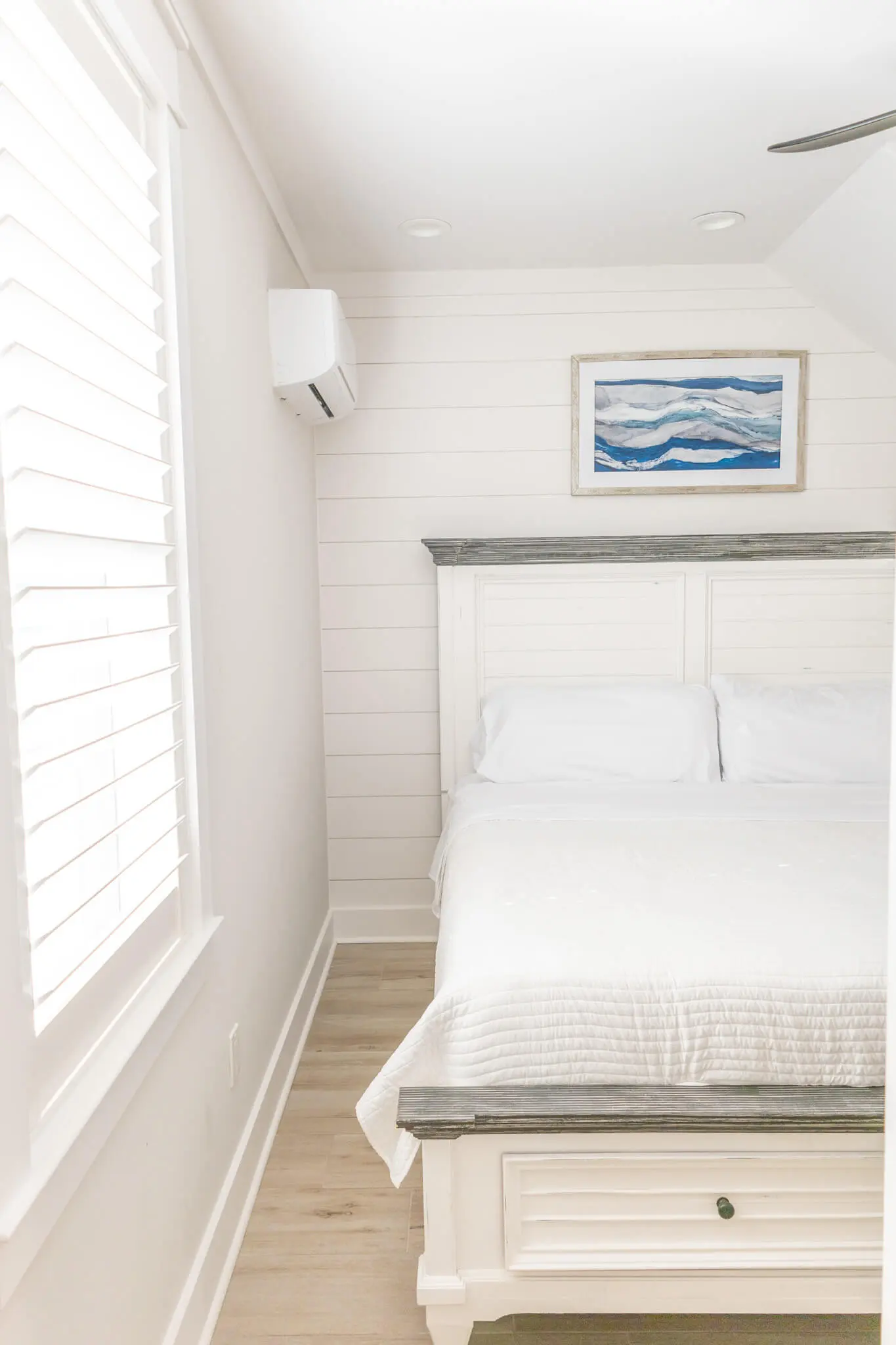 A bright, coastal bedroom featuring crisp white shiplap walls and professional interior finishes by Grayton Painting in Alys Beach.